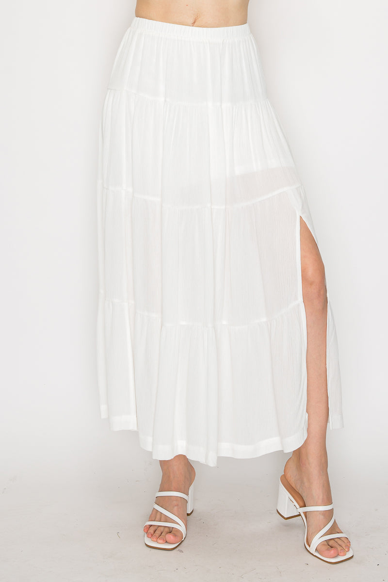 White skirt with a high slit worn by a person on a white background
